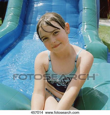 Girl sitting at the bottom of a water slide View Large Photo Image Picture - Girl sitting at the bottom of a water slide. Fotosearch