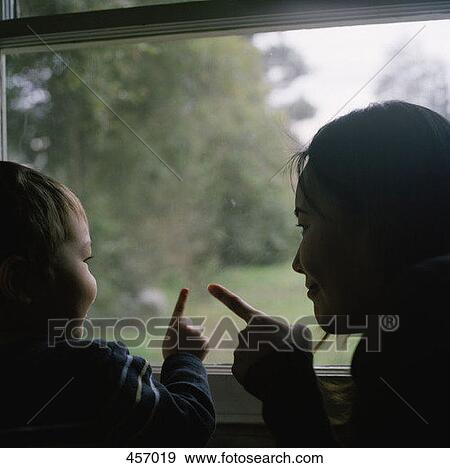 Stock Photo - Mother and son pointing out of the window. Fotosearch
