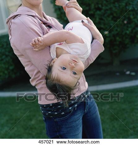 Stock Image - Mother carrying baby girl. Fotosearch