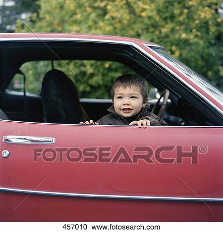 Young boy sitting in a car View Large Photo Image Stock Image - Young boy sitting in a car. Fotosearch