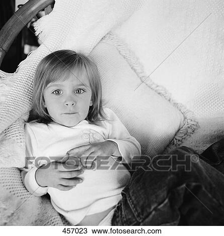 Young girl sitting in a chair View Large Photo Image Stock Image - Young girl sitting in a chair. Fotosearch