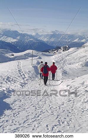 Stock Photograph - People hiking in snow covered mountains. Fotosearch