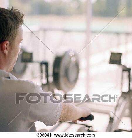 Over the shoulder view of man using rowing machine View Large Photo Image Stock Image - Over the shoulder view of man using rowing machine. Fotosearch