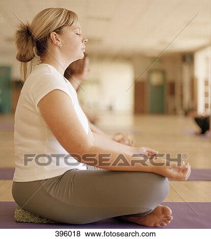 Woman meditating in class View Large Photo Image Stock Photo - Woman meditating in class. Fotosearch