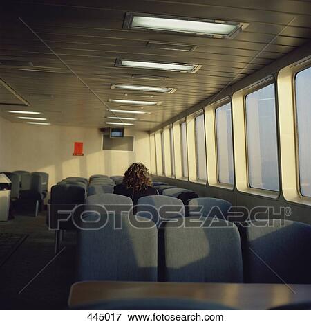 Stock Photo - Rear view of a woman sitting on a ferry. Fotosearch