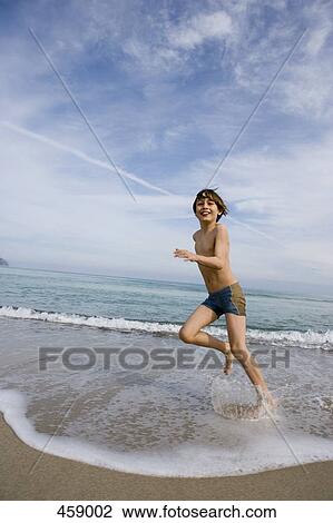 A boy running along a beach View Large Photo Image Stock Image - A boy running along a beach. Fotosearch
