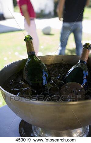 Stock Photo - Bottles of champagne on ice under an entertainment tent. Fotosearch