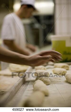 Detail of two men preparing dough in a bakery View Large Photo Image Stock Photo - Detail of two men preparing dough in a bakery. Fotosearch