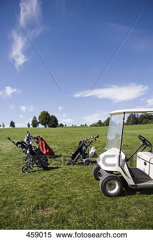 Stock Photography - Golf bags and a golf cart. Fotosearch