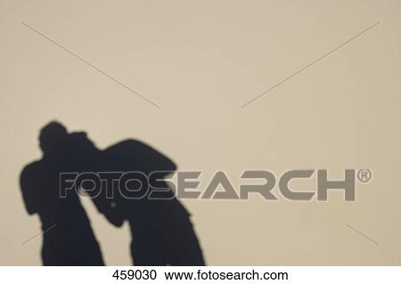 Shadow of two people on a wall View Large Photo Image Stock Image - Shadow of two people on a wall. Fotosearch