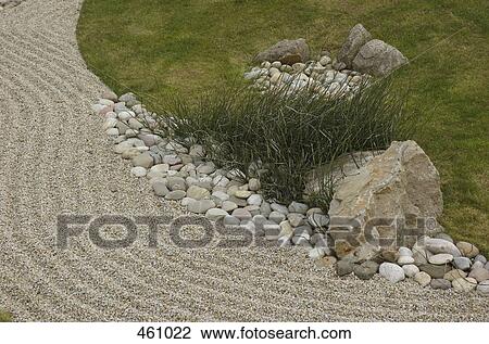 Stock Image - Grass and rock arrangement in a zen garden. Fotosearch
