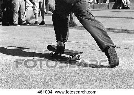 Low section of a man skate boarding in a town square View Large Photo Image Picture - Low section of a man skate boarding in a town square. Fotosearch