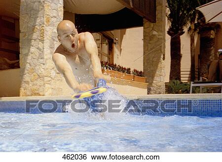 A man diving for a frisbee in a swimming pool View Large Photo Image Stock Photograph - A man diving for a frisbee in a swimming pool. Fotosearch