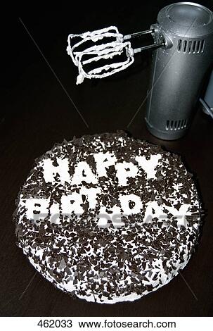 Stock Image - An electric mixer next to a birthday cake. Fotosearch