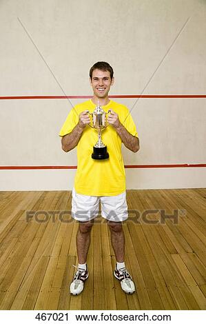 A man holding a squash trophy and smiling View Large Photo Image Stock Image - A man holding a squash trophy and smiling. Fotosearch