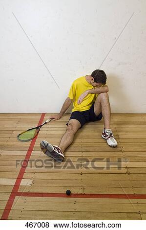 A man resting at the side of a squash court View Large Photo Image Stock Photo - A man resting at the side of a squash court. Fotosearch