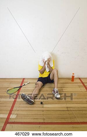 A man resting at the side of a squash court View Large Photo Image Stock Photo - A man resting at the side of a squash court. Fotosearch