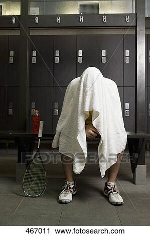 A man sitting in a locker room with a towel covering his head View Large Photo Image Stock Image - A man sitting in a locker room with a towel covering his head. Fotosearch