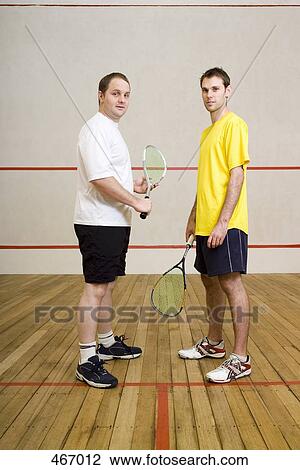 Two men standing on a squash court View Large Photo Image Stock Image - Two men standing on a squash court. Fotosearch