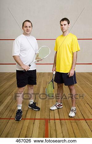 Stock Photograph - Two men standing on a squash court. Fotosearch