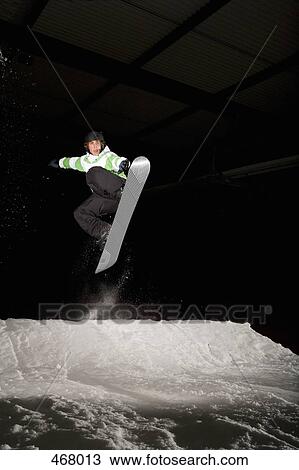 Snowboarder mid-air on a ski slope View Large Photo Image Stock Image - Snowboarder mid-air on a ski slope. Fotosearch
