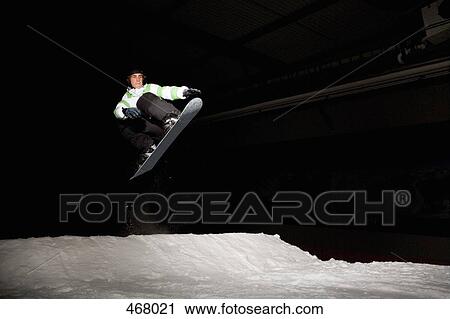 Snowboarder mid-air on a ski slope View Large Photo Image Stock Image - Snowboarder mid-air on a ski slope. Fotosearch