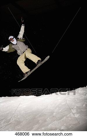 Snowboarder mid-air on a ski slope View Large Photo Image Stock Photograph - Snowboarder mid-air on a ski slope. Fotosearch