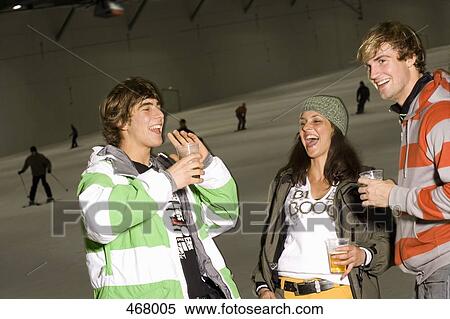 Three friends standing on a ski slope and drinking beer View Large Photo Image Stock Photography - Three friends standing on a ski slope and drinking beer. Fotosearch