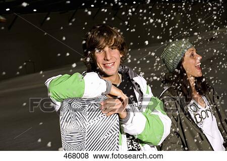 Young people standing on a ski slope in the snow View Large Photo Image Stock Photo - Young people standing on a ski slope in the snow. Fotosearch