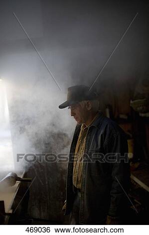 Stock Photograph - A senior man processing maple sugar. Fotosearch