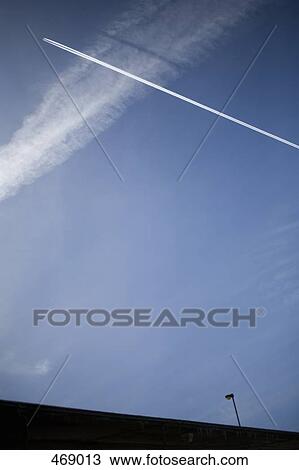 Airplane and vapor trails in the sky View Large Photo Image Stock Image - Airplane and vapor trails in the sky. Fotosearch