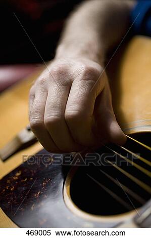 Stock Photography - Detail of a man playing an acoustic guitar. Fotosearch