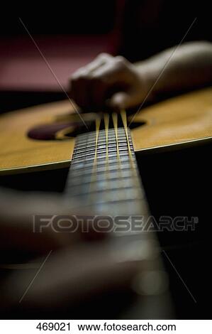 Detail of a person playing an acoustic guitar View Large Photo Image Stock Image - Detail of a person playing an acoustic guitar. Fotosearch
