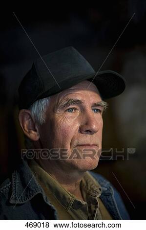 Stock Photo - Portrait of a senior man wearing a trucker's hat. Fotosearch