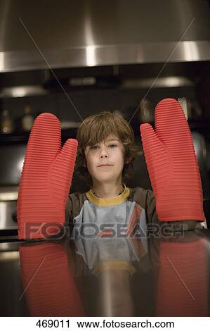 Young boy wearing large red oven mitts View Large Photo Image Stock Image - Young boy wearing large red oven mitts. Fotosearch