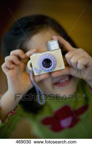 Stock Image - Young girl holding a toy camera. Fotosearch