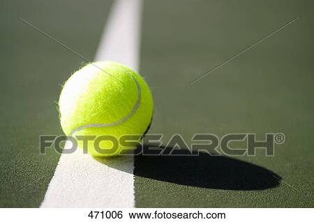 A tennis ball sitting on a white line View Large Photo Image Stock Photograph - A tennis ball sitting on a white line. Fotosearch