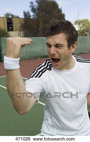 Stock Photograph - A tennis player celebrating. Fotosearch
