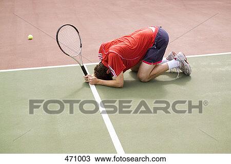 A tennis player crouching on the floor in defeat View Large Photo Image Stock Image - A tennis player crouching on the floor in defeat. Fotosearch