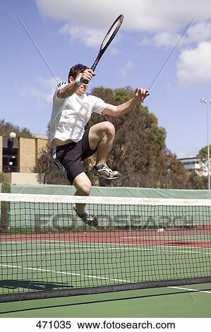 A tennis player leaping over a tennis net View Large Photo Image Stock Photography - A tennis player leaping over a tennis net. Fotosearch
