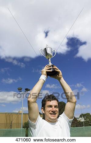 A tennis player lifting a trophy View Large Photo Image Stock Image - A tennis player lifting a trophy. Fotosearch