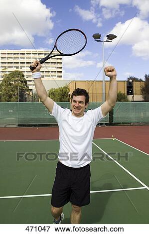 Stock Photo - A tennis player raising his arms in celebration. Fotosearch