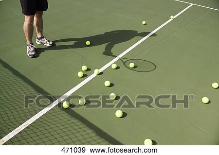 Low section of a tennis player with balls scattered on the court View Large Photo Image Stock Photo - Low section of a tennis player with balls scattered on the court. Fotosearch