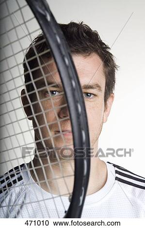 Portrait of a tennis player holding a tennis racquet in front of his face View Large Photo Image Stock Image - Portrait of a tennis player holding a tennis racquet in front of his face. Fotosearch