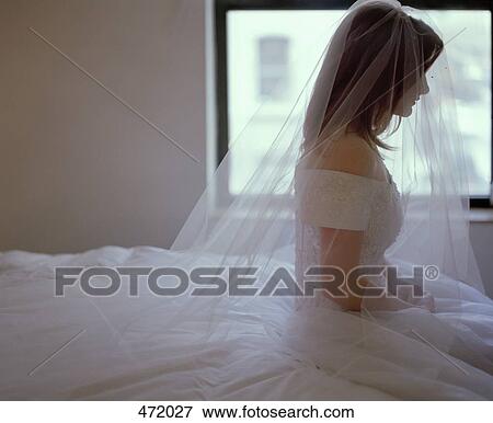 A bride sitting on a bed View Large Photo Image Stock Photo - A bride sitting on a bed. Fotosearch