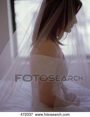 Stock Photo - A bride sitting on a bed. Fotosearch