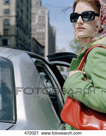 A stylish woman getting into a car View Large Photo Image Stock Image - A stylish woman getting into a car. Fotosearch