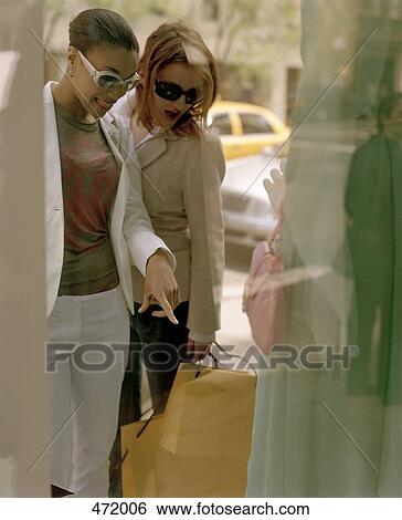 Two woman looking in a shop window View Large Photo Image Stock Photograph - Two woman looking in a shop window. Fotosearch