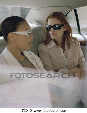 Two women sitting in the back of a taxi View Large Photo Image Stock Image - Two women sitting in the back of a taxi. Fotosearch