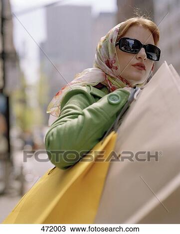 Woman carrying shopping bags and crossing a city street View Large Photo Image Stock Image - Woman carrying shopping bags and crossing a city street. Fotosearch